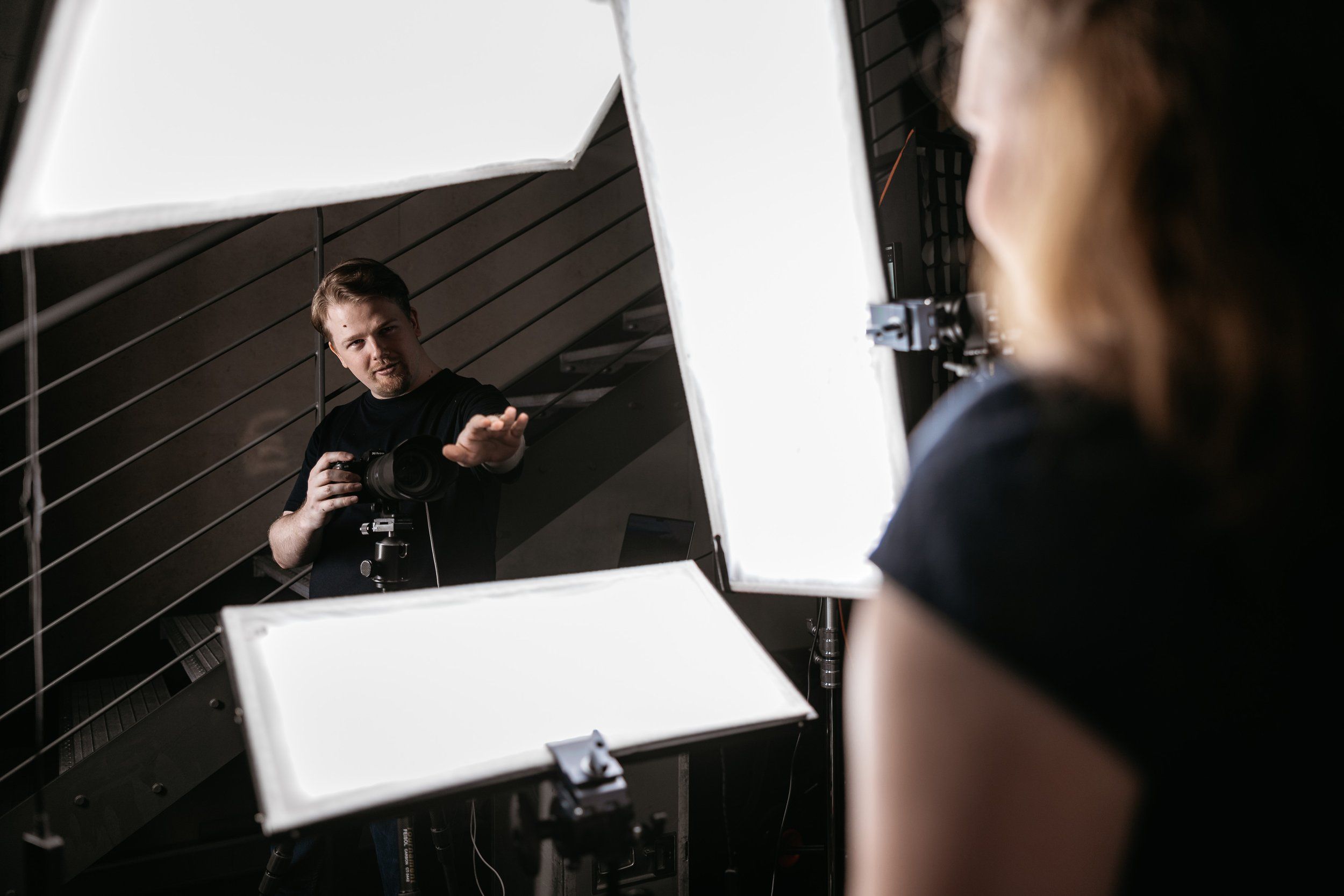 Oliver Wagner leitet eine Kundin beim Headshot-Shooting im Kölner Studio an, umgeben von Studiolicht